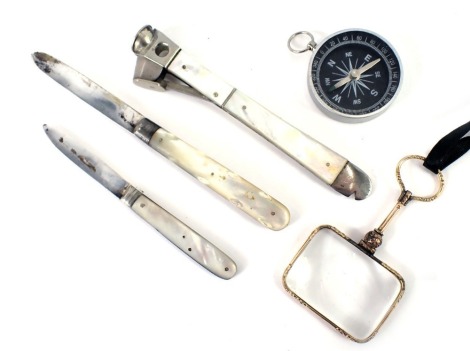 A mother of pearl handled and steel pen knife, a mother of pearl steel cigar cutter, a gilt handled magnifying glass, and a compass, etc. (5)