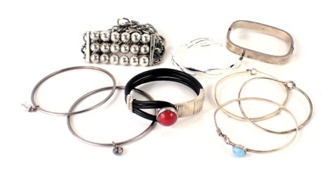 Various modern bangles, comprising stone set, Buckingham, and others, a hammered rectangular bangle stamped 925, and others. (a quantity)