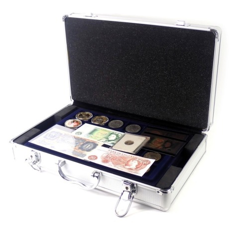 An aluminium coin case and contents, to include collectors fifty pence pieces, WWF, football medallion, one pound notes, shillings, pennies, halfpennies, etc. (1 box)