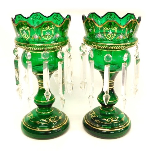 A pair of Victorian green tinted glass table lustres, each decorated in raised enamels and gilt with flowers, shields etc. on a domed foot, 36cm high.