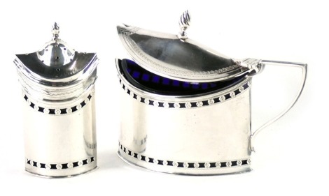 An oval silver mustard pot, the hinged lid with flame finial, the base with pierced bands, a blue glass liner, and a matching pepper pot, silver weight 3.95oz.