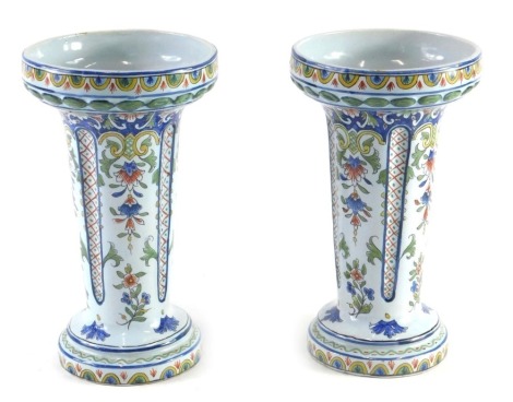 A pair of Fourmaintraux Faience vases, made at Courquin Desvres in Northern France, each decorated with flowers and foliate scrolls, numbers to either side, 24cm high.