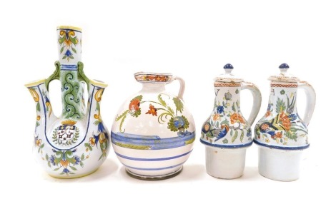 A collection of Faience items, to include a 19thC Faience jug decorated with flowers, a 19thC Fourmaintraux Frere Desvres four spouted vase, and a pair of 18thC Rouen Faience Huile and Vinegar bottles. (4)