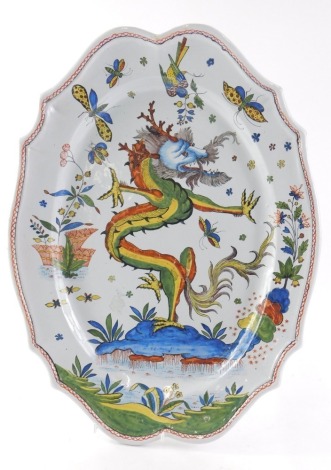 An 19thC faience Quimper HB oval porquier baux, with a fluted border, earthenware polychrome decoration of flowers, butterflies, birds and central dragon, marked HB to reverse, 51cm diameter.