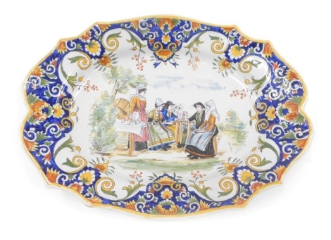 A 19thC Fourmaintraux Freres oval platter or meat dish, decorated with figures around a table, within foliate and floral borders, 36cm wide.