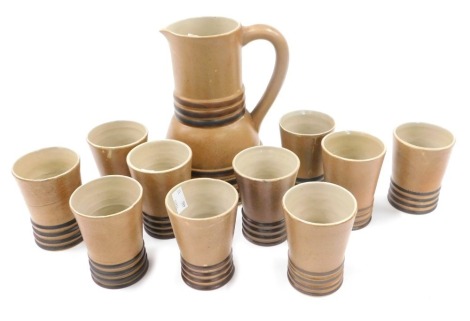 A Quimper Faience Art Deco cider set, comprising jug and ten beakers, each with a brown glaze.