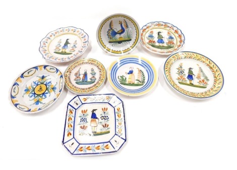 A collection of mainly Quimper Faience plates, various sizes, with typical figural design, and a plate decorated with a peacock. (8)