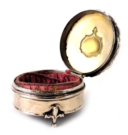 An Edward VII Selfridge & Co silver jewellery casket, of circular form, with a fluted outer border with vacant cartouche, and a pink material lined interior with black leather inset base, hallmarks rubbed, stamped Selfridge & Co, 6cm diameter, 2.67oz gros