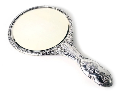 A George V silver backed dressing table mirror, with embossed children with wings, and scroll handle, Chester 1910.