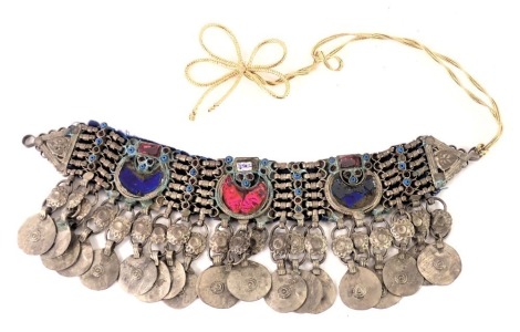 A middle eastern choker, set with three sectional design, with an italic blue and pink detail, with white metal drop rings, on a gold thread strand, 27cm diameter.