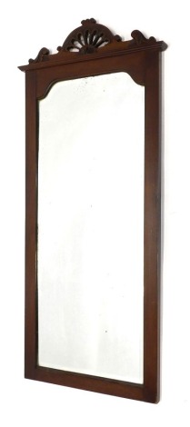 An Edwardian walnut wall mirror, with a pierced crest, arched bevel plate, 112cm high, 49cm wide, a smaller example 46cm wide.