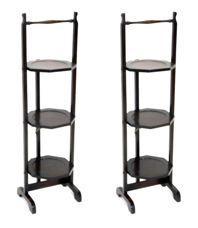 Two oak three tier folding cake stands, each with shaped end supports.