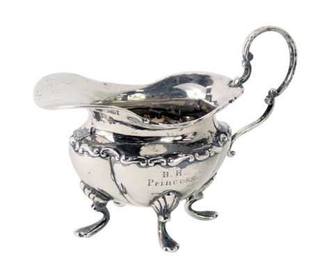 A late Victorian small silver cream jug, of lobed form, with four scroll shaped feet, Sheffield 1899, 2.74oz.