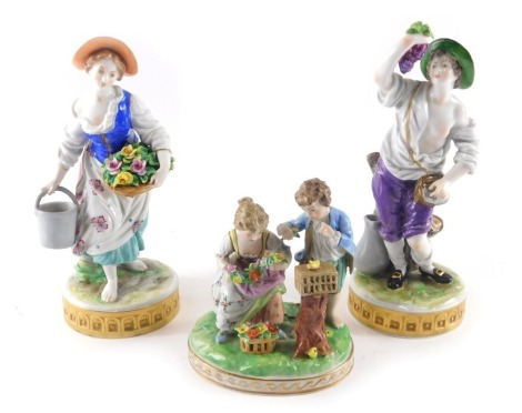 A pair of German porcelain figures, modelled in the form of a gentleman and a lady, one holding flowers the other grapes, and a similar Dresden porcelain figure group. (3)