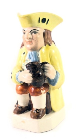 A late Staffordshire Toby jug, formed as a gentleman in yellow overcoat, carrying stoneware vessel, marked MN to underside, 22cm high.