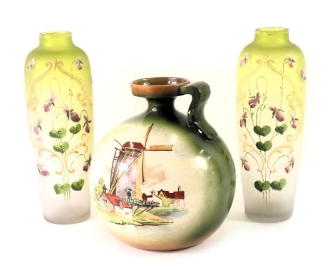 A Foley China Faience jug, with windmill decoration, 15cm high, and a pair of green hand painted Art Nouveau style glass vases, 19cm high. (3)