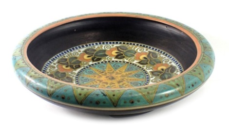 A Dania of Holland fruit bowl, with a moulded and painted border, with orange rim on a blue and green flagged ground, signed to underside, 31cm diameter.