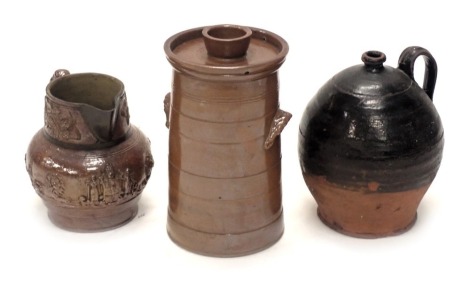 A 19thC dark stoneware flagon, with associated copper spout, 25cm high, stoneware water filter, and a terracotta and black glazed stoneware flagon, 30cm high.