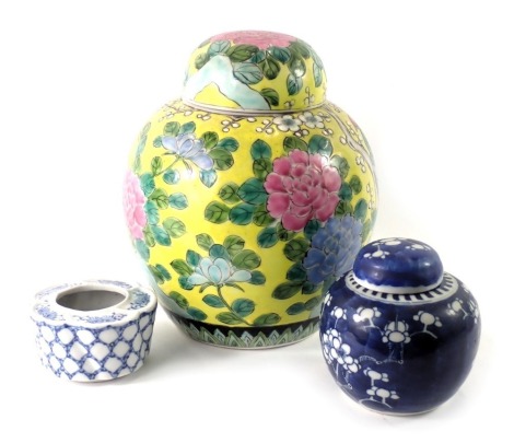 Three items of oriental ceramics, comprising a prunus pattern ginger jar and cover, 10cm high, a yellow ground ginger jar and cover, 23cm high, and a blue brush pot, 5cm high. (3)