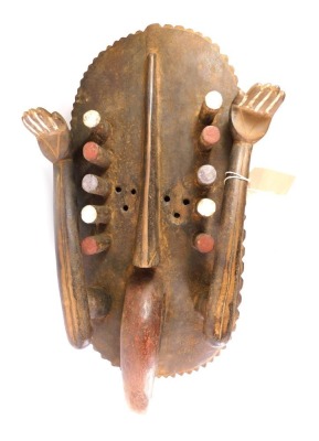 An African tribal Grebo Kru surrender mask, with two raised hands, shaped tongue, Liberia circa 1950, 60cm high.