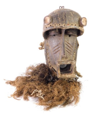 A Kran warrior's mask, with stylised jaws, embellished with bells, etc., 48cm high.