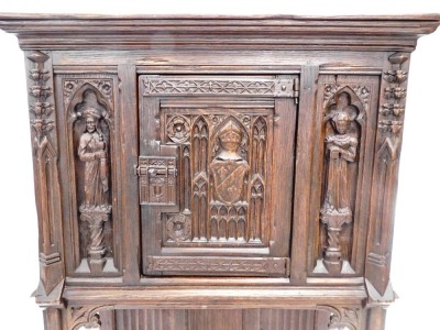 A 19thC oak carved Gothic cabinet, the rectangular top above a carved and frieze door, with two figure caryatids, and a lower shelf, on stiles, 142cm high, 85cm wide, 44cm deep. - 2