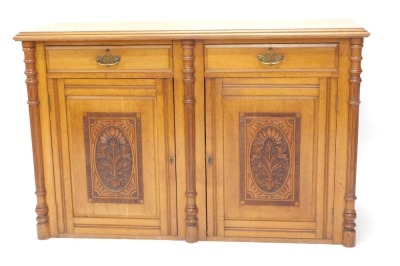 A late Victorian oak sideboard, the top with a moulded edge, above two frieze drawers, and two carved doors flanked by fluted cylindrical plasters, lacking base, 93cm high, 147cm wide.