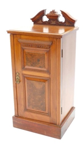 A late Victorian walnut bedside cabinet, the top with a broken pediment and a moulded edge above single door with figured panels on a plinth, 85cm high, 40cm wide.