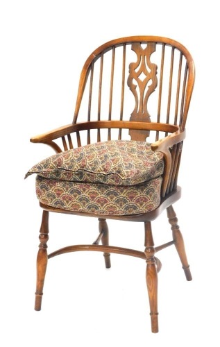 An ash and elm Windsor chair, the pierced splat, shaped arms and solid seat, on turned legs with crinoline stretcher.