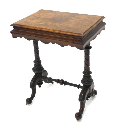 A Victorian walnut and figured walnut work table, the rectangular hinged inlaid top with a moulded edge enclosing a fitted interior, on spirally turned and leaf carved supports, with similar stretcher, on scroll carved splayed legs with ceramic castors, 7