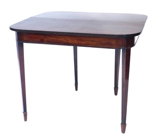 An early 19thC mahogany fold over tea table, the rectangular top with rounded front corners and a reeded edge, above a plain frieze, on square tapering legs, with spade feet, 74cm high, 90cm wide.