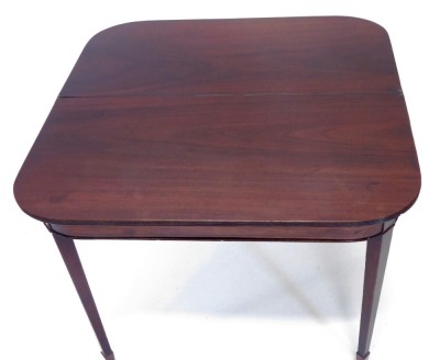 An early 19thC mahogany fold over tea table, the rectangular top with rounded front corners and a reeded edge, above a plain frieze, on square tapering legs, with spade feet, 74cm high, 90cm wide. - 2