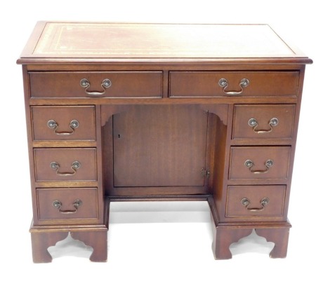 A mahogany pedestal desk, the rectangular top with a red gilt leather insert, above an arrangement of eight drawers on bracket feet, 90cm wide.