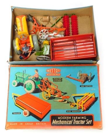 A Mettoy Playthings Modern Farming Mechanical Tractor set, comprising tinplate tractor and plough (AF), hay cutter, disc harrow, and trailer, boxed.