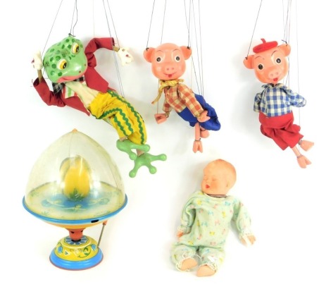 Bygone toys, including a tinplate spinning top, a frog puppet, two little pigs puppet, and a Marlon Creations sleeping baby doll with clockwork music box. (5)