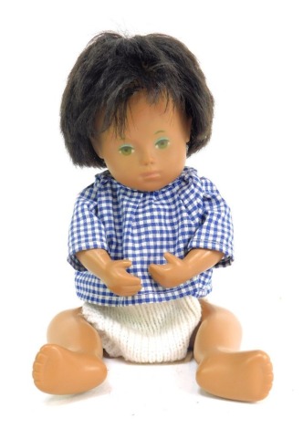 A 1970s Sasha doll, of girl with brown hair and green eyes, in cream and chequered dress, 25cm high.