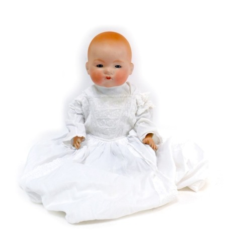 An Armand Marseille German bisque headed doll, with roll blue eyes, stamped AMGM34118, with material articulated limbs, in white christening gown, 58cm high.