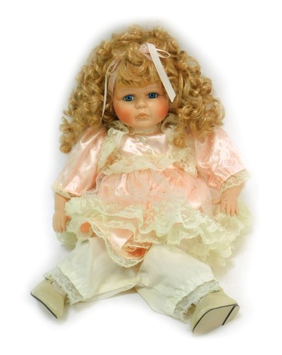 A bisque headed doll, of girl with blue fixed eyes, with bisque body unmarked, in pink flowing dress, 41cm high.