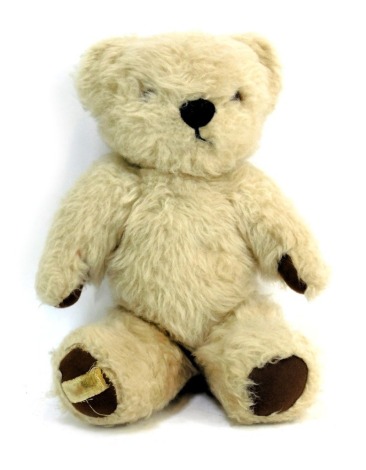 A Merrythought vintage cream jointed Teddy bear, with brown pad feet, 32cm high.