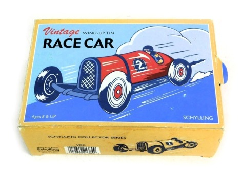 A Schylling vintage wind up tin race car, boxed.