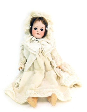 A German porcelain Simon Halbig bisque headed doll, female with blue eyes, teeth and brown hair, on articulated limb body, stamped 4000 410, in lace dress and bonnet, 36cm high.