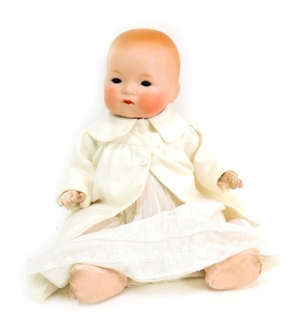 An Armand Marseille German bisque headed doll, with blue eyes, and articulated limbs, in white Christening gown with overcoat, 34cm high.