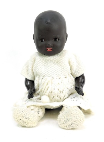 An Armand Marseille German bisque headed doll, with blackened face, with roll brown eyes and open mouth, stamped AM Germany 351-1 1/2K, on articulated limb body, with wool work dress, 30cm high.