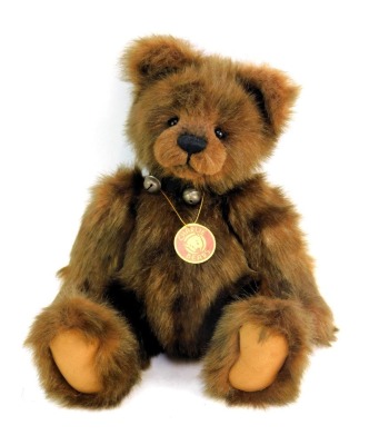 A Charlie Bears Teddy bear, brown, with bell collar.