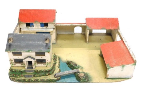 A painted farmyard scene, with cottage and river, outbuildings, and a Robilt toy building, boxed.