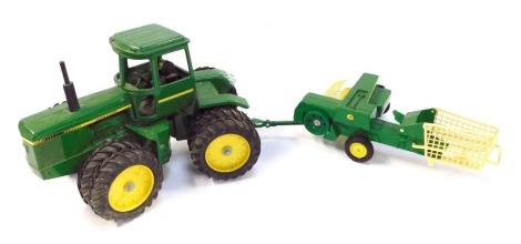 An Ertl John Deere diecast tractor, and a 585 baler. (2)