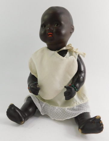 A bisque headed doll, with blackened face, articulated limbs, stamped AS, with cream bib, 41cm high.