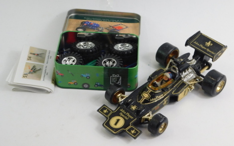 A Corgi John Player Special F1 car, and an Apples to Pears Tractor in a tin. (2)