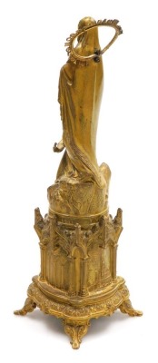 A late 19thC French gilt metal souvenir of Lourdes, showing St Bernadette before the Virgin Mary, beneath title "Miracle du Clerge, Five Aviril 1858", the base of gothic form, cast in relief with churches and gothic windows, raised on four scroll feet, 3 - 2