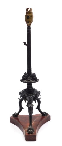 A late 19thC French bronze table lamp, of cast fluted column form, with masks and scrolling leaves, raised on three lion's head and paw feet, above a red marble triform base, with shade, 59cm high.